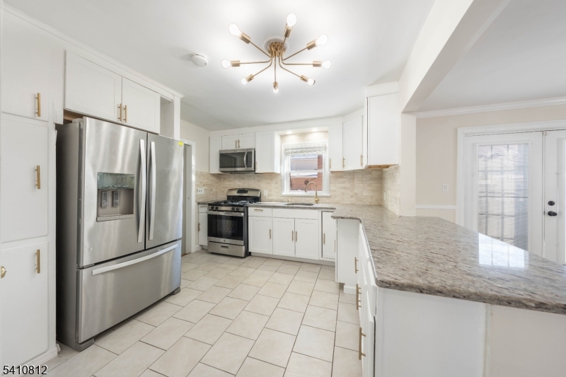 985 Arnet Avenue Union, NJ 07083 - Photo 10 of 26 a kitchen with granite countertop a refrigerator a sink a stove a microwave and island