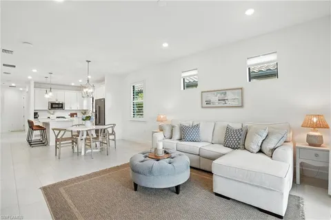 a living room with furniture and a dining table with garden view