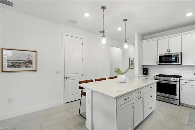 a kitchen with a sink and a stove top oven with wooden floor