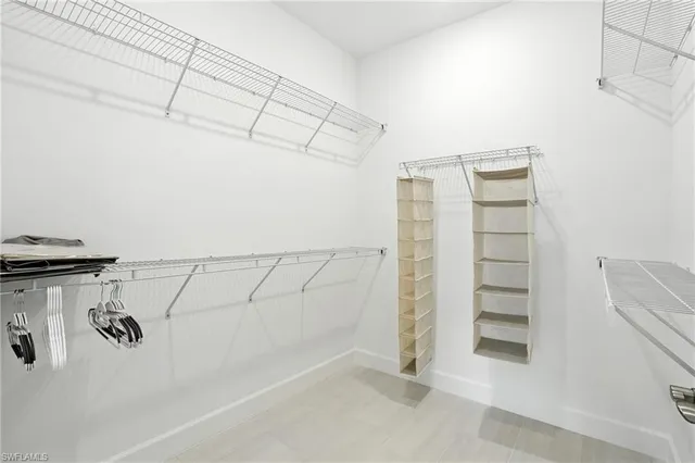 a view of walk in closet with clothes