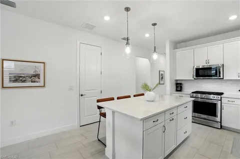 a kitchen with a sink and a stove top oven with wooden floor