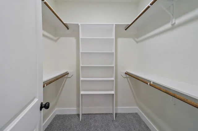 a view of walk in closet with empty racks