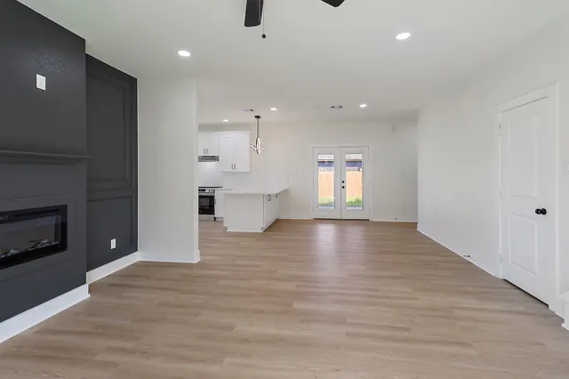 a view of empty room with kitchen and fireplace