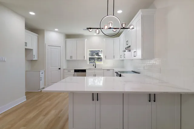 a view of a kitchen with wooden floor and stainless steel appliances