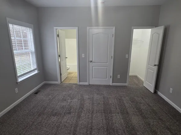 an empty room with windows and closet