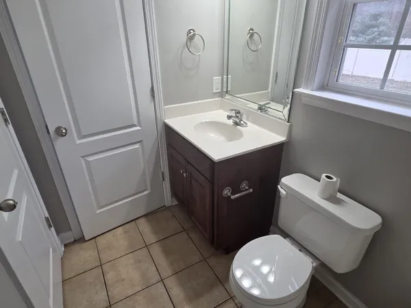 a bathroom with a sink vanity mirror and toilet