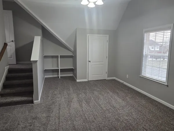 a view of an empty room with a fireplace and a window