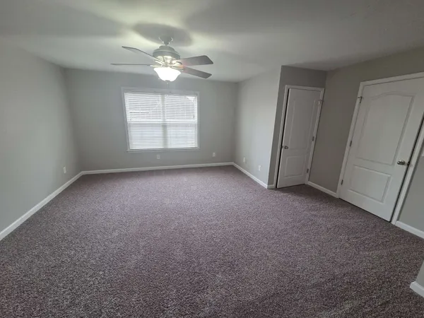a view of a livingroom with a ceiling fan and window