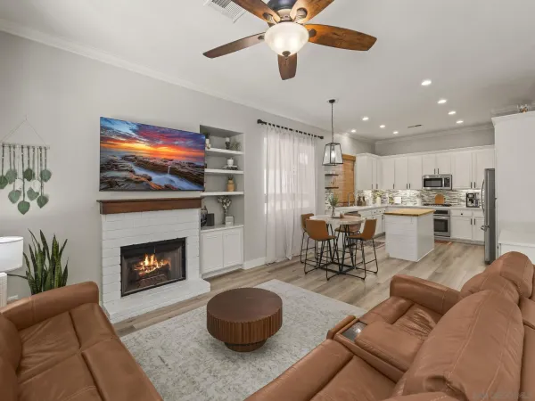 a living room with furniture kitchen view and a chandelier