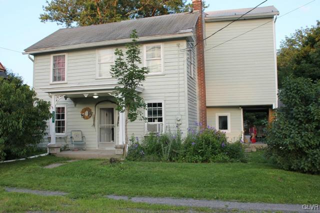 a front view of a house with a yard and potted plants