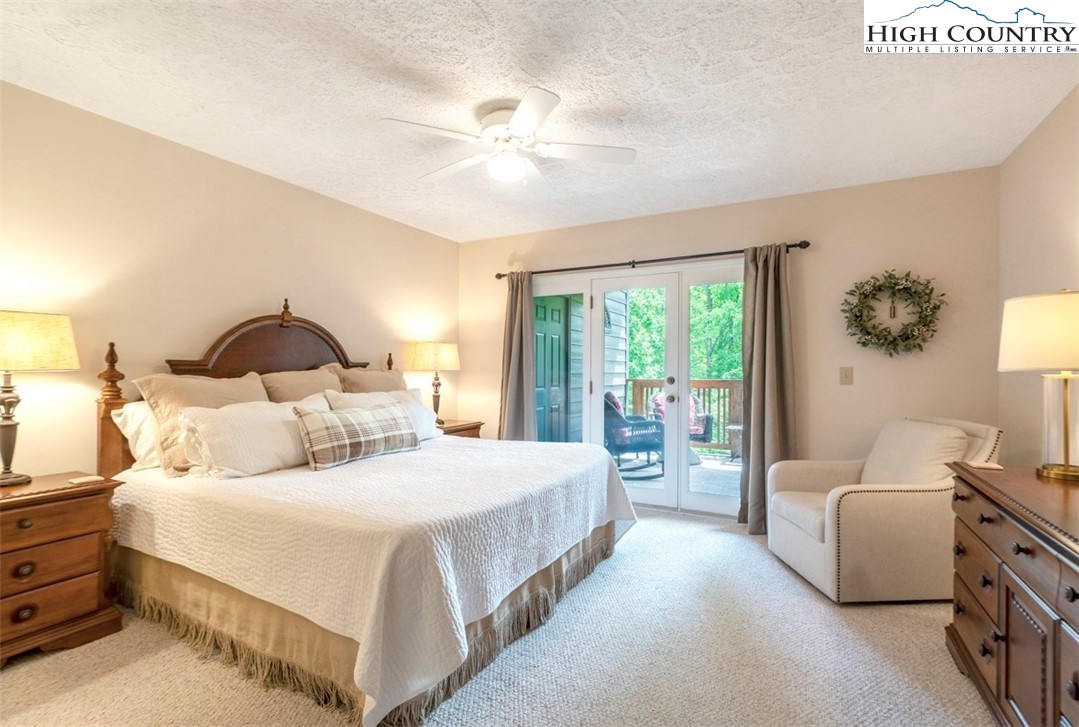 166 Still Lake Drive, Unit 222 Boone, NC 28607 - Photo 18 of 37 a bedroom with a large bed and a chandelier