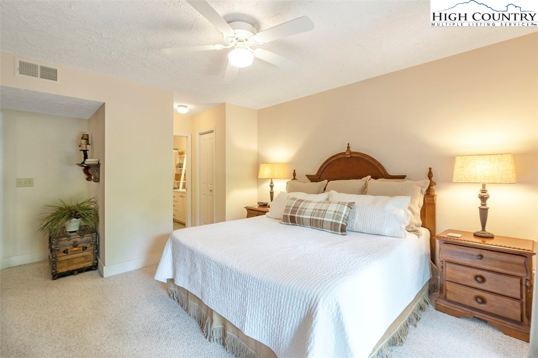 166 Still Lake Drive, Unit 222 Boone, NC 28607 - Photo 21 of 37 a bedroom with a bed and a chandelier