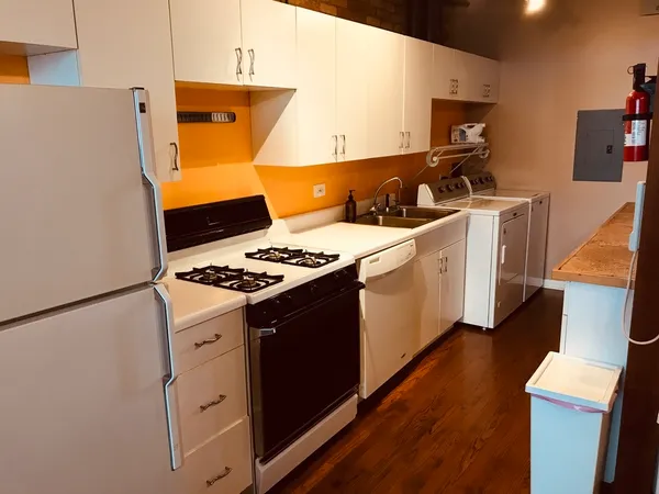 a kitchen with stainless steel appliances a refrigerator a stove and wooden floor