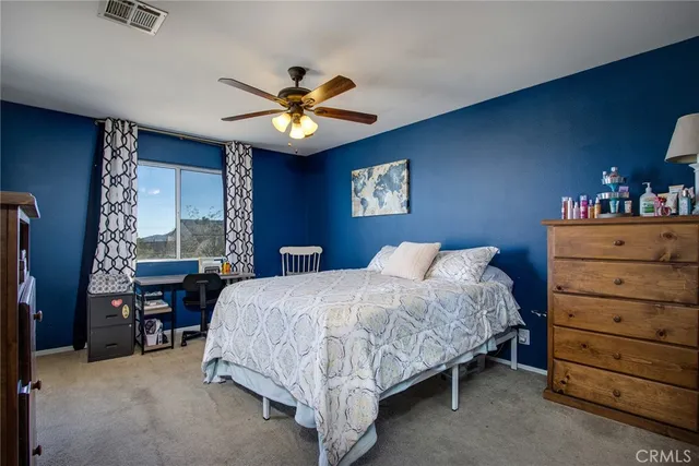 a bedroom with a large bed and a flat tv screen