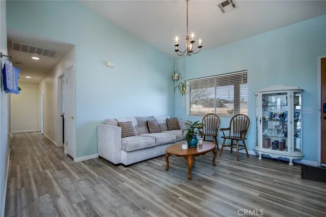 a living room with furniture chandelier and a table