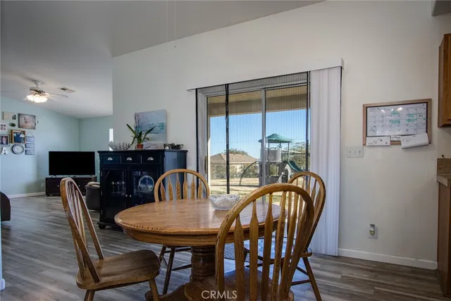 a kitchen with stainless steel appliances granite countertop a dining table chairs a sink and dishwasher a refrigerator with wooden floor