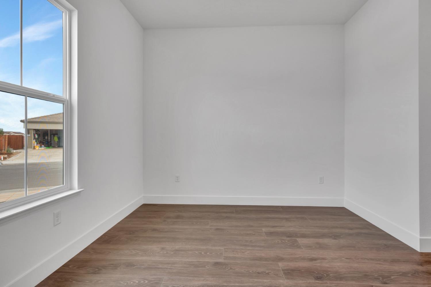 4327 Hooded Crow Way Rancho Cordova, CA 95742 - Photo 34 of 58 a view of an empty room with wooden floor and a window