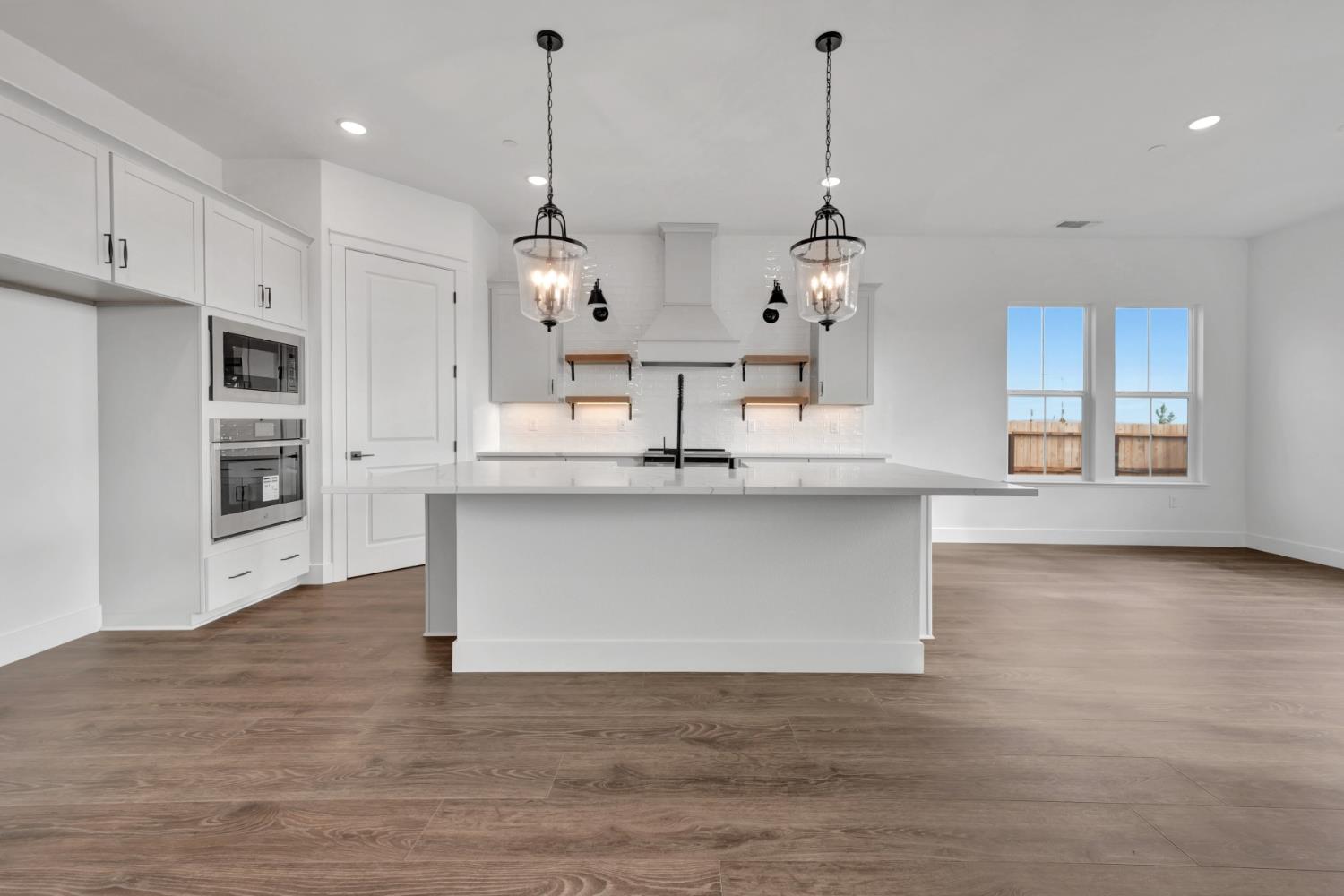 4327 Hooded Crow Way Rancho Cordova, CA 95742 - Photo 6 of 58 a view of a kitchen with kitchen island a sink stainless steel appliances and cabinets