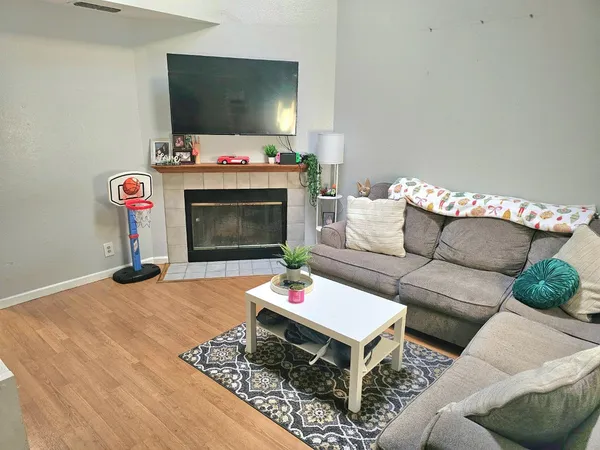 a living room with furniture a flat screen tv and a fireplace