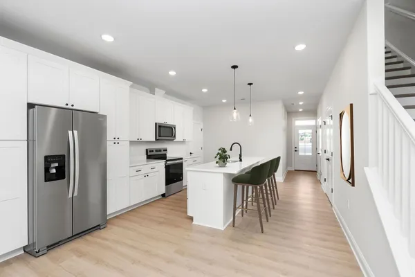 a kitchen with a refrigerator a sink and a stove top oven