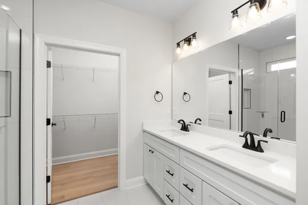 a bathroom with a double vanity sink mirror and shower