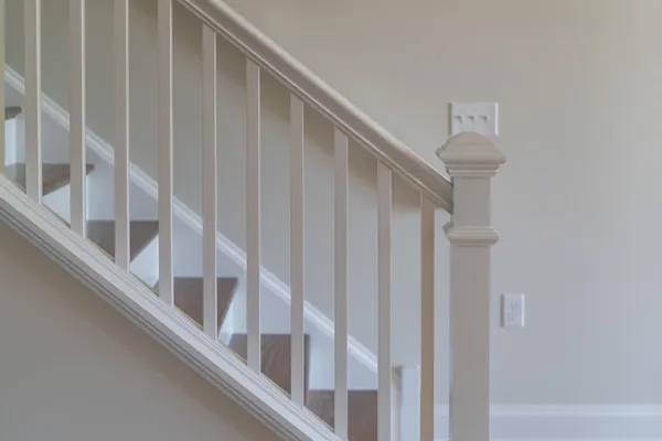 a view of staircase with railing and white walls