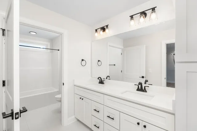 a bathroom with a double vanity sink mirror and shower