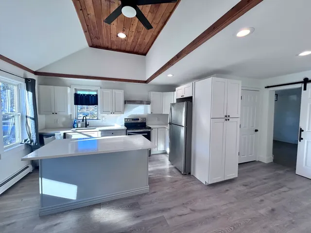 a living room with furniture and kitchen view