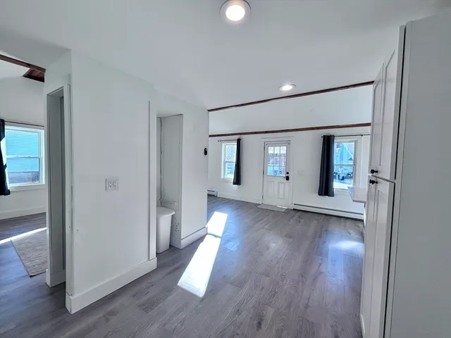 a view of a big room with wooden floor and windows