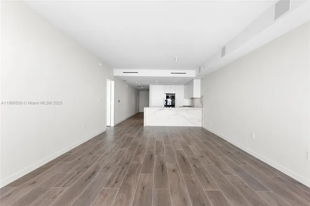 a view of an empty room and wooden floor