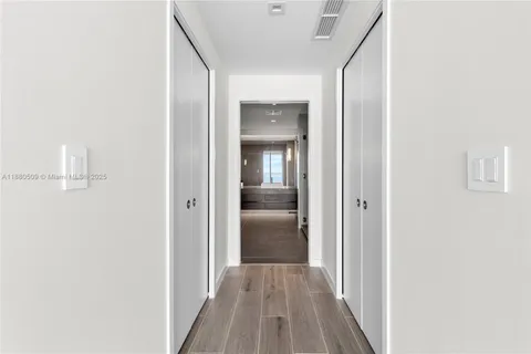 a view of a hallway with wooden floor