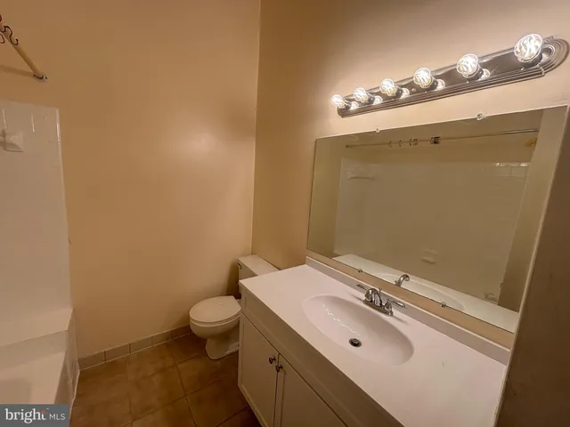 a bathroom with a sink a toilet a mirror and shower