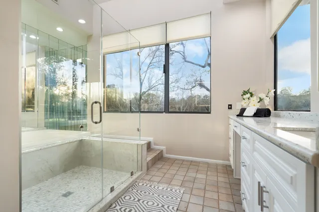 a bathroom with a granite countertop sink a large mirror and a shower