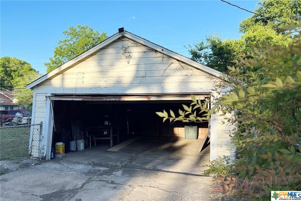 809 North 8th Street Temple, TX 76501 - Photo 19 of 20 A detached garage offers ample storage and workspace, with a wide opening for easy vehicle access.