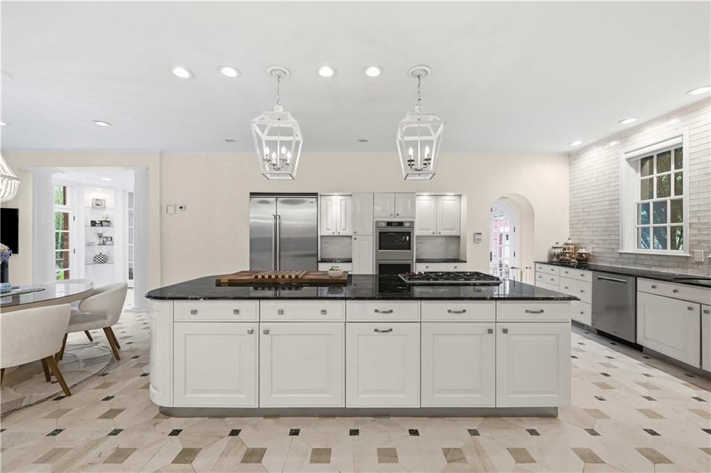 898 Persimmon Road Sewickley, PA 15143 - Photo 24 of 50 Opening to the loggia and connecting the home’s main living spaces, the kitchen serves as a bright central hub with grand scale, statement lighting, new double ovens, and a new six-burner Wolf range.