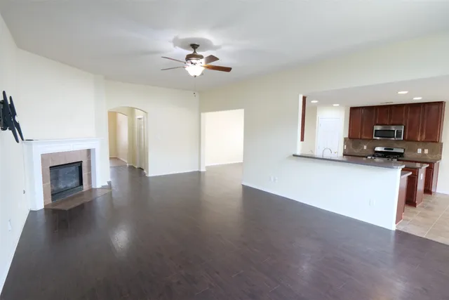a view of a kitchen with furniture a ceiling fan and wooden floor