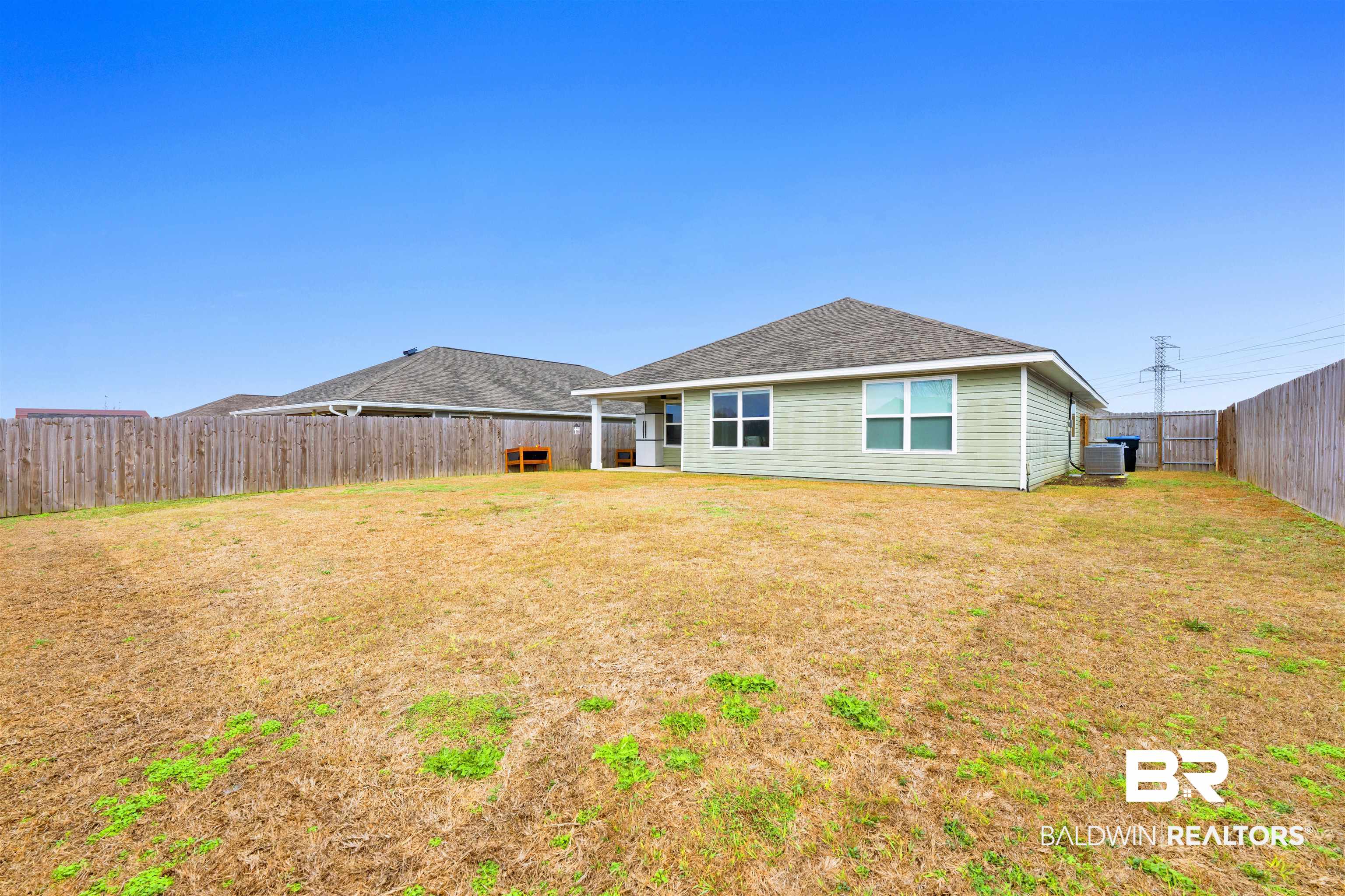 10763 Paget Drive North Mobile, AL 36608 - Photo 23 of 24 Back of house with a fenced backyard and roof with shingles
