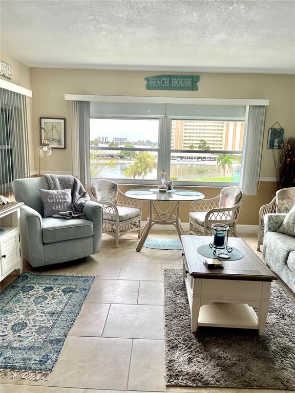 4650 Cove Circle, Unit 402 St. Petersburg, FL 33708 - Photo 13 of 36 a living room with furniture and floor to ceiling windows
