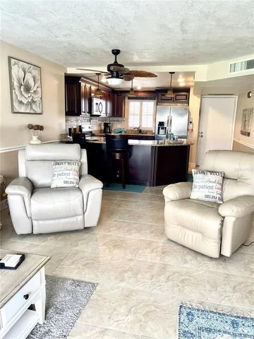 a living room with furniture and kitchen view