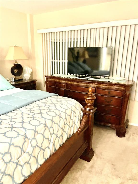 4650 Cove Circle, Unit 402 St. Petersburg, FL 33708 - Photo 19 of 36 a bed sitting in a bedroom next to a window