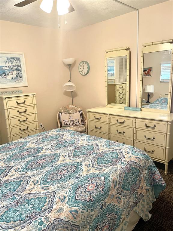 4650 Cove Circle, Unit 402 St. Petersburg, FL 33708 - Photo 30 of 36 a bedroom with a bed and a cabinets