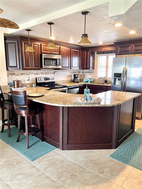4650 Cove Circle, Unit 402 St. Petersburg, FL 33708 - Photo 4 of 36 a kitchen with stainless steel appliances granite countertop a stove a sink and a microwave