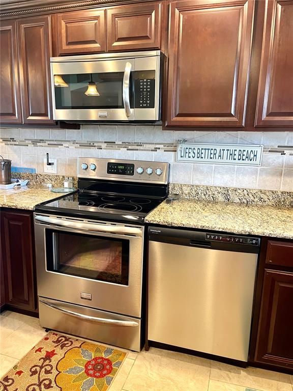 4650 Cove Circle, Unit 402 St. Petersburg, FL 33708 - Photo 7 of 36 a kitchen with granite countertop cabinets and steel stainless steel appliances