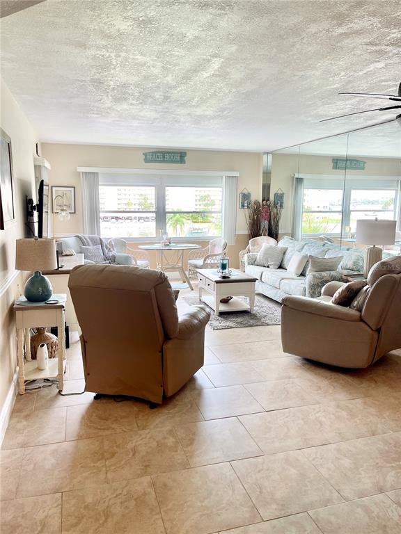 4650 Cove Circle, Unit 402 St. Petersburg, FL 33708 - Photo 10 of 36 a living room with furniture and a large window