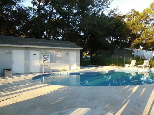 a view of a house with backyard and swimming pool