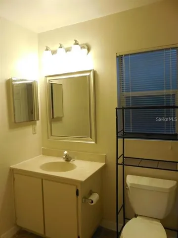 a bathroom with a sink mirror vanity and toilet