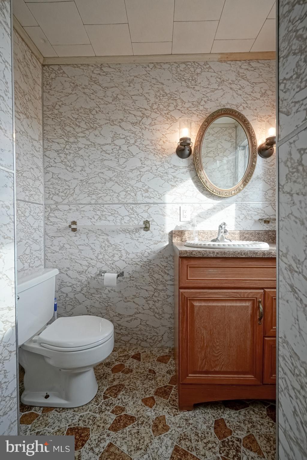 124 North 1st Road Hammonton, NJ 08037 - Photo 27 of 29 a bathroom with a toilet a sink and mirror