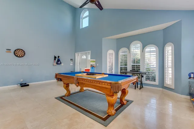 a living room with furniture pool table and wooden floor