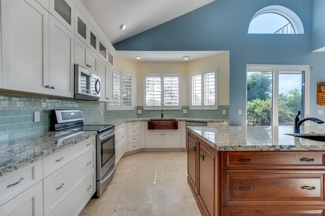 a kitchen with granite countertop stainless steel appliances stove a sink and a granite counter tops