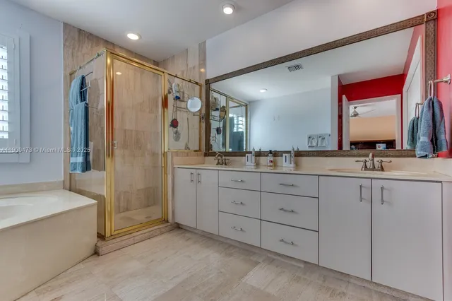 a bathroom with a double vanity sink mirror and shower